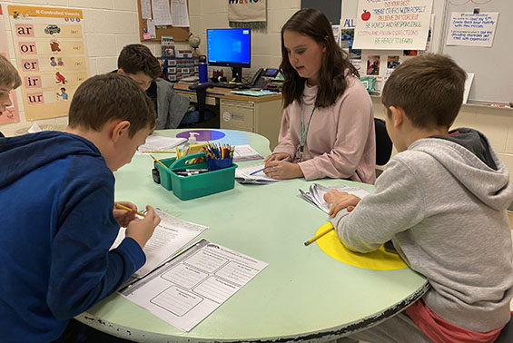 Teacher working with students at a table