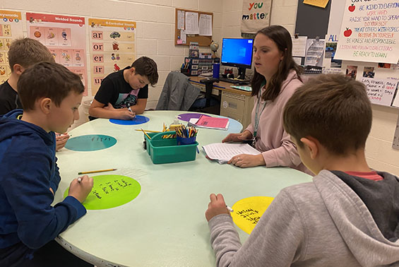 Teacher working with students at a table