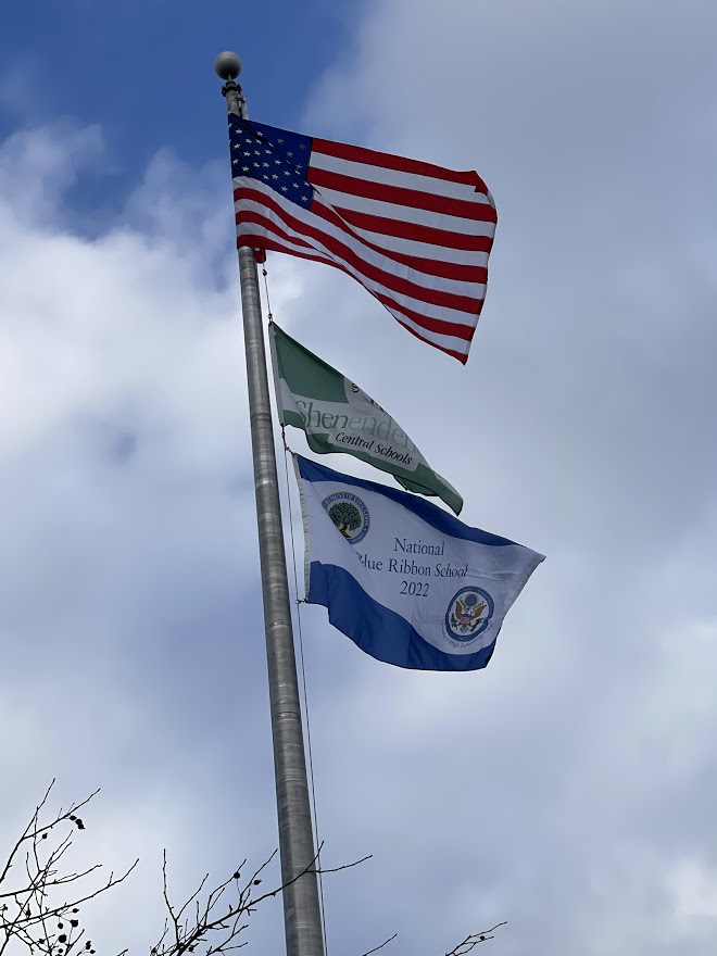 Blue ribbon flag flies with the American flag and Shen flag