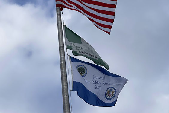 Blue ribbon flag flies with the American flag and Shen flag