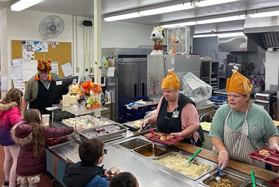 women wearing turkey hats serving lunch