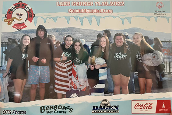 a group of students posing in front of Lake George