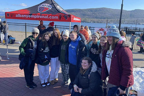 a group of students posing in front of Lake George