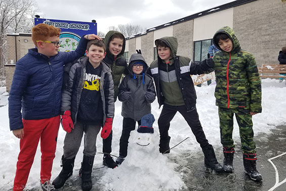 students standing around a snowman