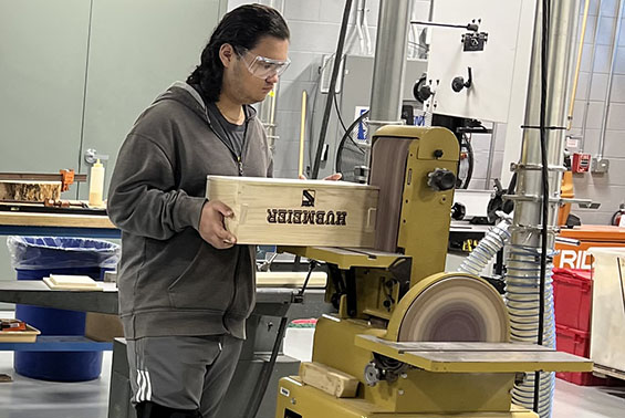HS students in Manufacturing Systems work on their custom tool boxes using wood shop equipment and the laser engraver.