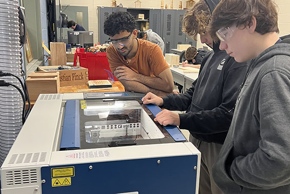 HS students in Manufacturing Systems work on their custom tool boxes using wood shop equipment and the laser engraver.