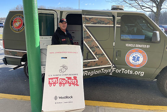 A marine in front of Toys for Tots van