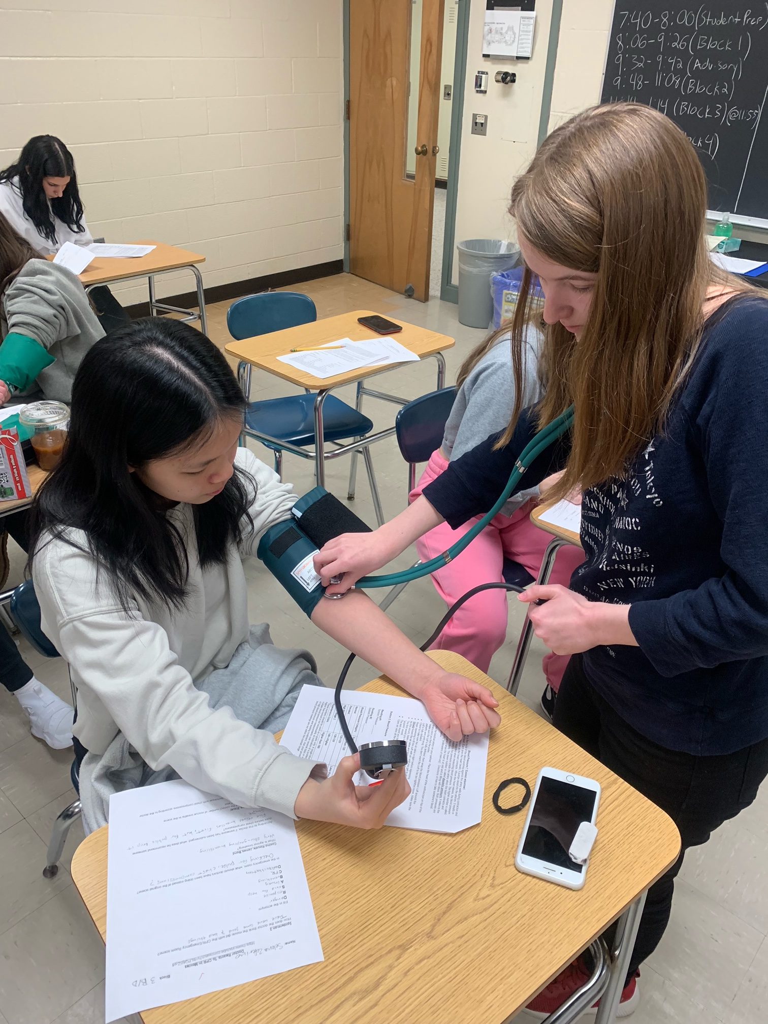 High school students in the Health Sciences for Medical Careers course practice career skills with oximeters,  sphygmomanometers, and stethoscopes.
