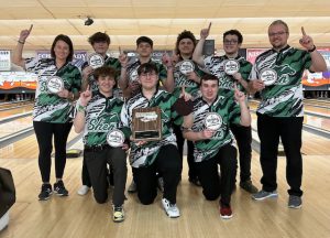 Boys Varsity Bowlers hold up awards. 