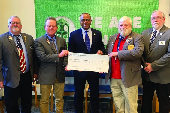 Elks members hold check with Dr. Robinson