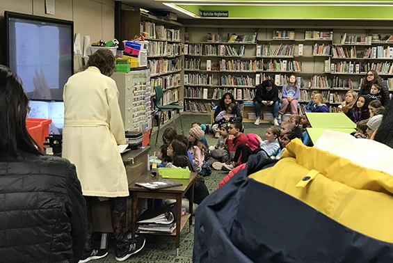 Students listen to a story read by Okte librarian Mrs. Holland at the Pajama Literacy Jam on 1/26.