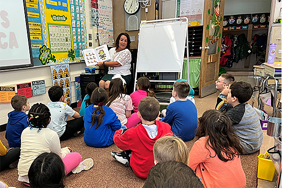 Adult reads to kids in the classroom