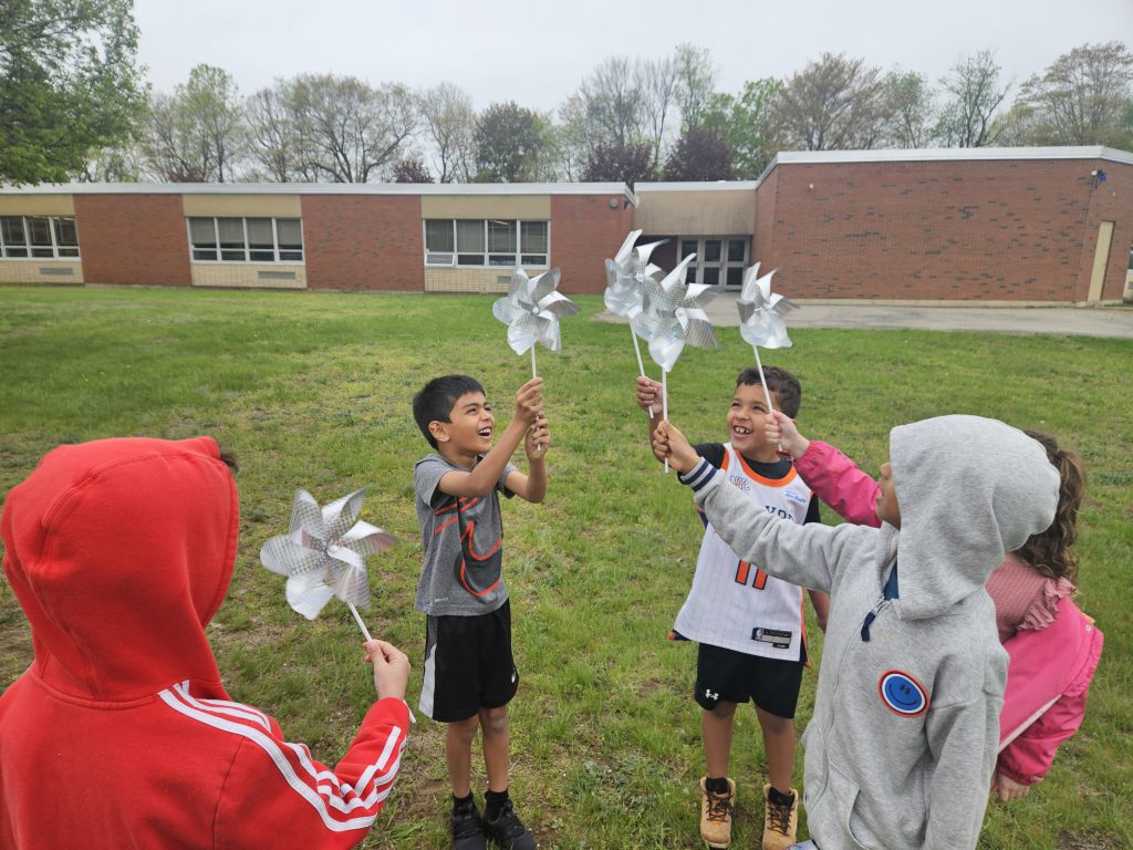 Students holding pinwheels outside
